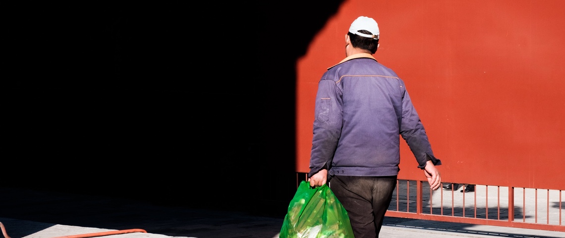 Business poubelle : Shanghai punit ceux qui ne recyclent pas, et les géants de la tech en profitent Un homme asiatique de dos tient un sac poubelle