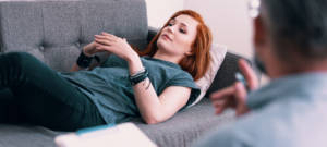 Une femme allongée sur un canapé chez le psy