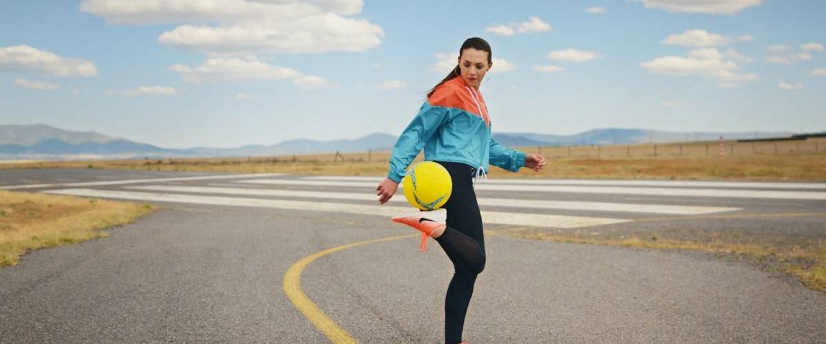 Uber US supporte le football féminin dans sa dernière campagne. Une joueuse de football jongle avec son ballon sur une route désertique