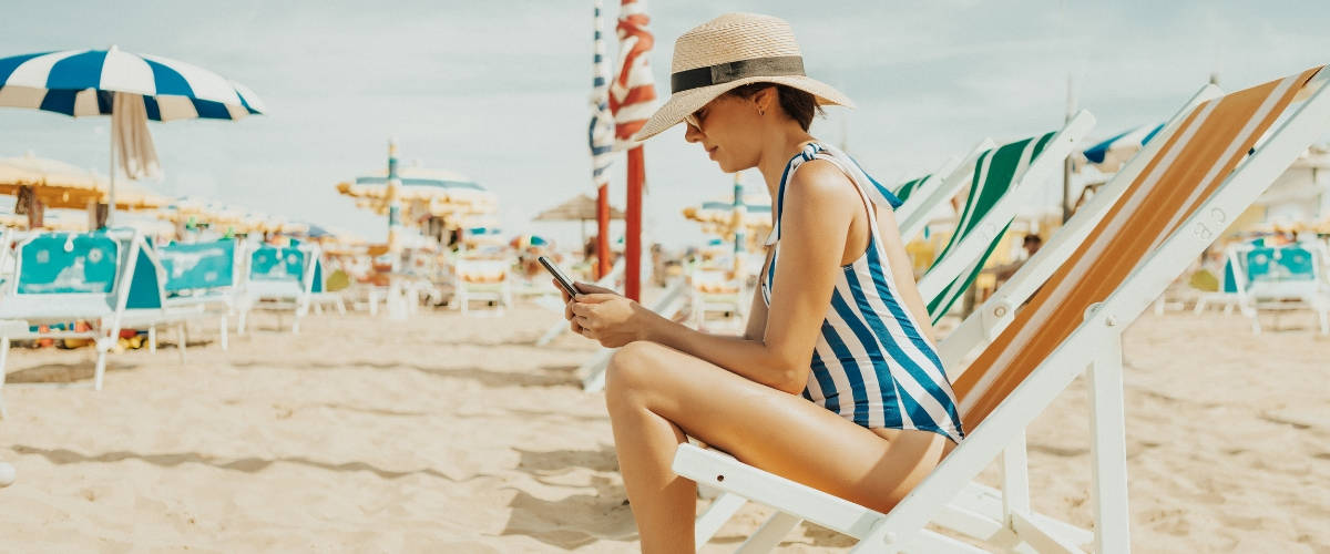 Gérer ses réseaux sociaux en vacances Une femme en maillot de bain à la plage