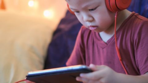 Youtube va rester ouvert à tous les contenus, même les plus controversés un petit garçon avec des gros écouteurs regarde un écran