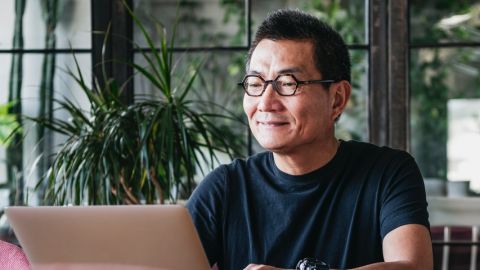 Homme asiatique tape sur un ordinateur