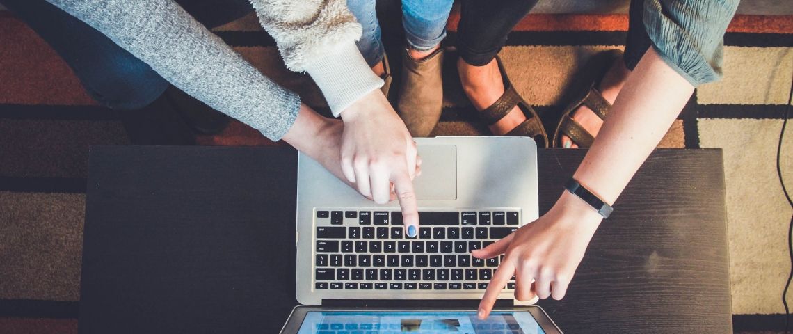 Le reciblage publicitaire, un levier pour convertir plus Trois femmes pointent leurs doigts vers un écran
