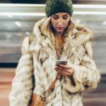 Une femme avec un manteau en fourrure sur le quai d'un métro