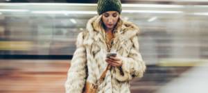 Une femme avec un manteau en fourrure sur le quai d'un métro