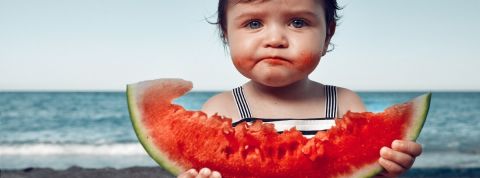 Les meilleures applications anti-gaspi Une petite fille à la plage en train de manger une pastèque