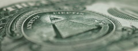 les fake news : un marché publicitaire comme les autres ? Un gros plan sur un billet en dollars avec la pyramide et la devise in god we trust