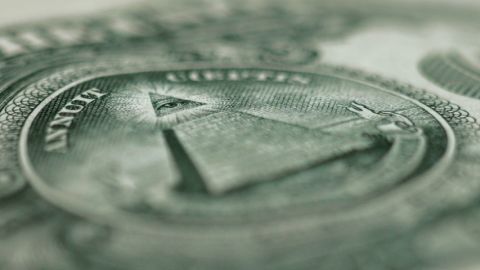 Un gros plan sur un billet en dollars avec la pyramide et la devise in god we trust