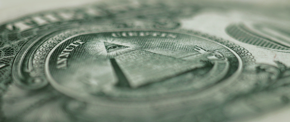 les fake news : un marché publicitaire comme les autres ? Un gros plan sur un billet en dollars avec la pyramide et la devise in god we trust