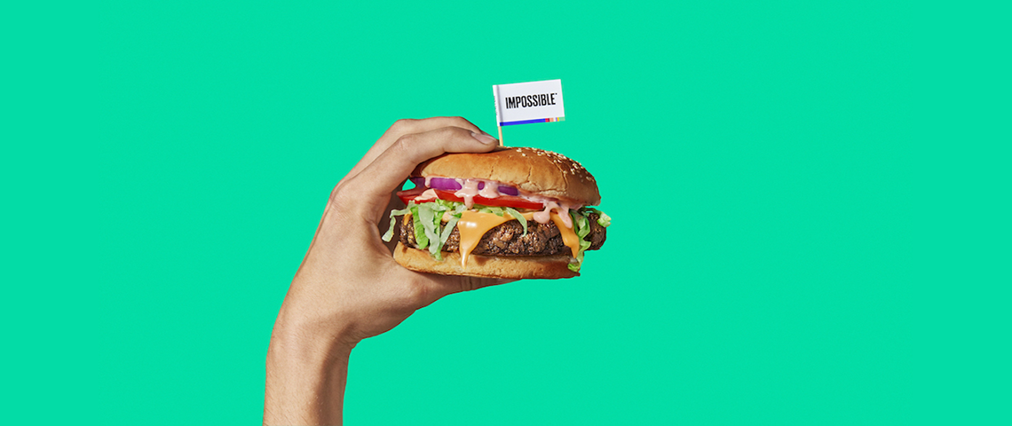 4 burgers qui veulent sauver la planète Une main qui tient un hamburger sur un fond vert