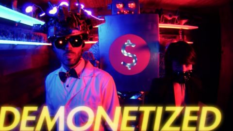 Un savant fou et une femme dans la pénombre avec un robot en arrière fond.