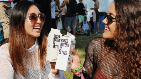 Deux jeunes femmes qui boivent de l'eau à un festival