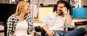 Un homme et une femme en train de rire au bureau