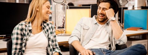 Sommes-nous vraiment amis avec nos collègues ? Un homme et une femme en train de rire au bureau