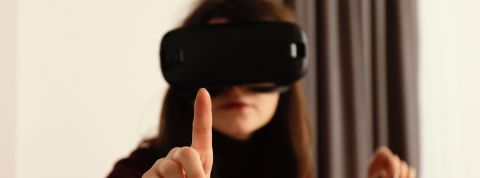 Une peau artificielle promet d'ajouter un sens à la réalité virtuelle Femme portant un casque de réalité virtuelle essaye de toucher un objet