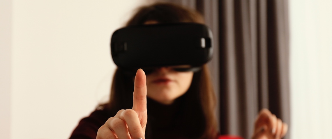 Une peau artificielle promet d'ajouter un sens à la réalité virtuelle Femme portant un casque de réalité virtuelle essaye de toucher un objet