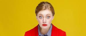 Une femme en blazer rouge s'étonne