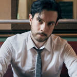 un jeune homme en cravate assis dans un bistro