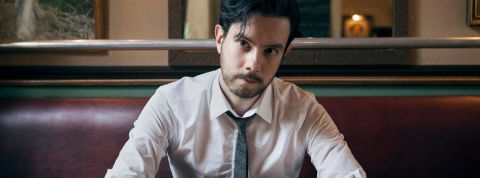 un jeune homme en cravate assis dans un bistro