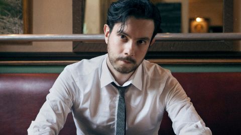 un jeune homme en cravate assis dans un bistro