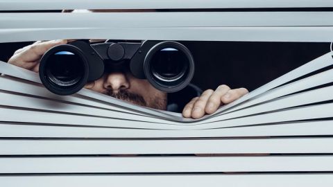 homme qui espionne ses voisins