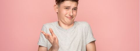 jeune garçon sceptique sur fond rose