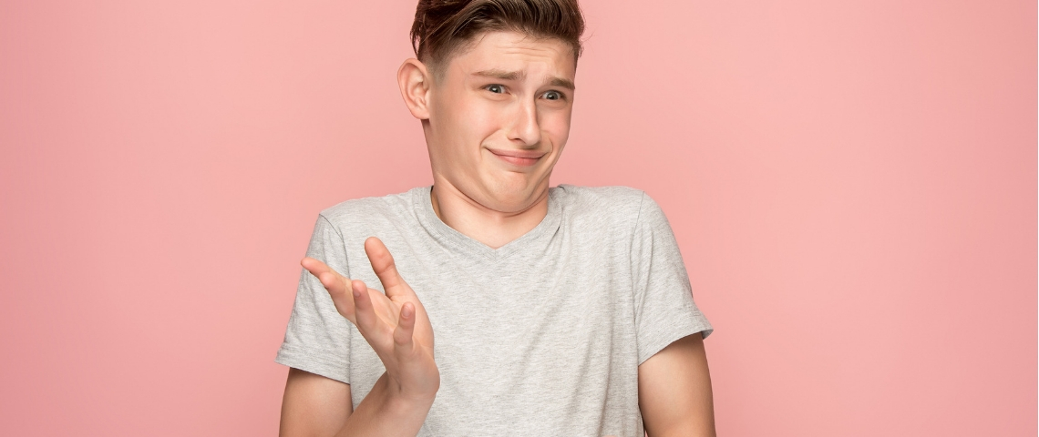 jeune garçon sceptique sur fond rose