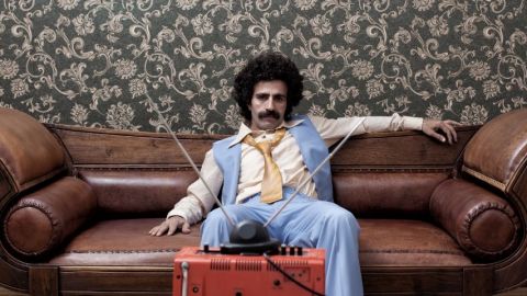 Un homme déprimé sur son canapé, dans une décoration très seventies.