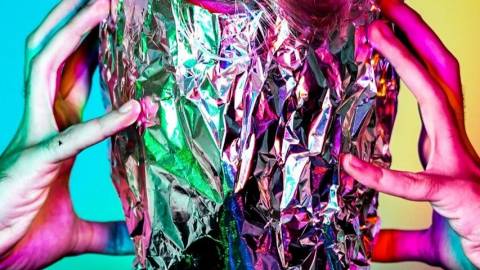 Un humain se tient la tête enroulée dans de l'aluminium