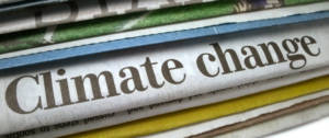Des journeaux papiers avec le titre changement climatique dessus.