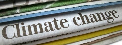 la presse au secours du climat Des journeaux papiers avec le titre changement climatique dessus.