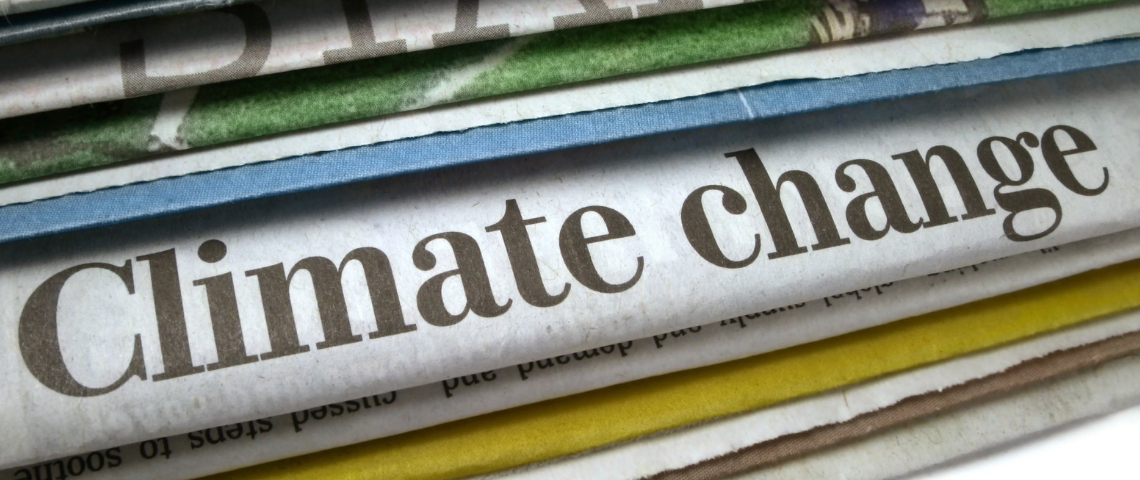 la presse au secours du climat Des journeaux papiers avec le titre changement climatique dessus.