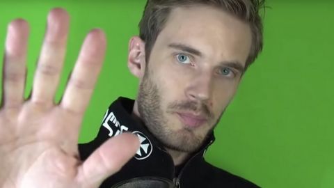 un jeune homme sur un fond vert tend la main vers la caméra