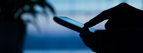 Trois façons de se faire pirater son téléphone Main utilisant un smartphone dans l'ombre