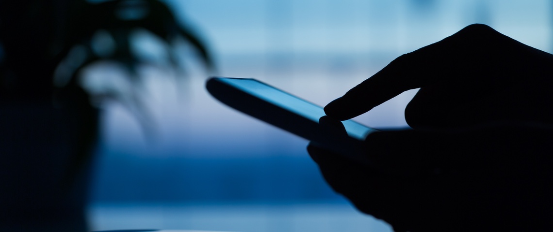 Trois façons de se faire pirater son téléphone Main utilisant un smartphone dans l'ombre