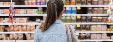 Yuka fait bouger les industriels Une femme de dos regardant un rayon de supermarché