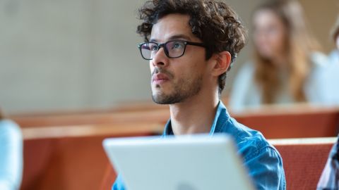 Étudiant derrière un ordinateur en salle de classe