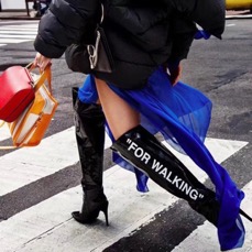 Gros plan sur les bottes d'un mannequin qui traverse la route