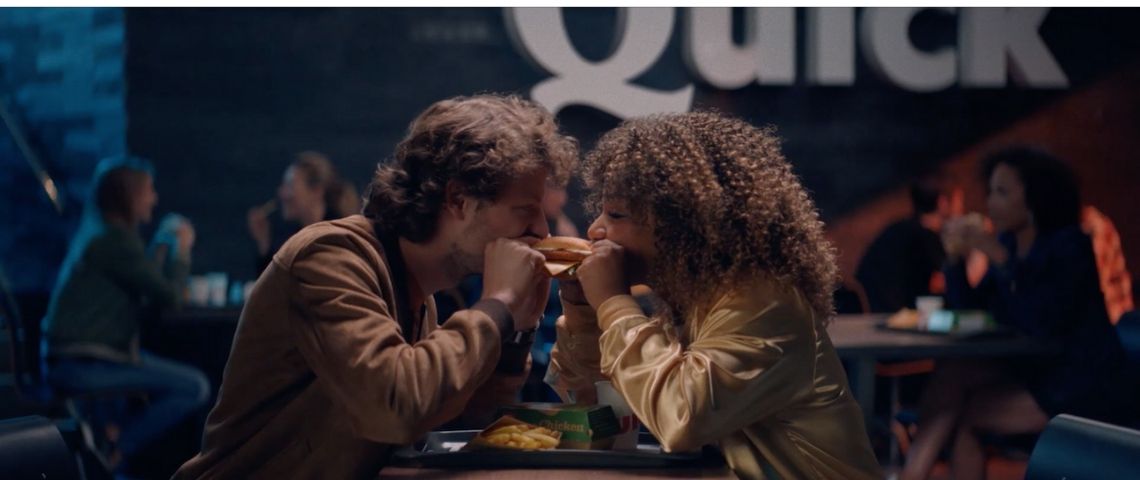 L'agence Ponk signe la dernière campagne de Quick Visuel de deux personnes e ntrain de croquer dans le même hamburger