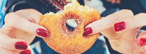 Étude sur l'impact du nutri-score sur la consommation Les mains d'une femme qui tiennent un donut entamé