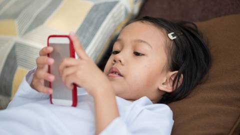 une petite fille asiatique devant son portable