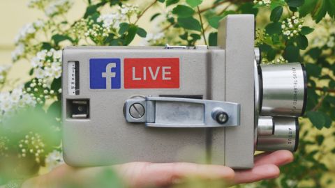 une vieille caméra avec un stickers Facebook live dessus