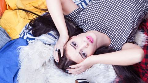 Femmes stressée allongée sur une pile de vêtements