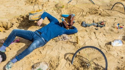 un homme masqué allongé sur le sable