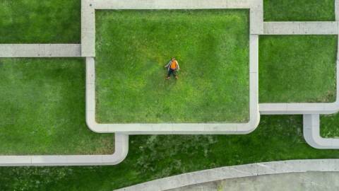 Un homme allongé sur le toit d'un immeuble recouvert de pelouse