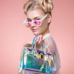 Une femme blonde avec des lunettes de soleil et un sac à main