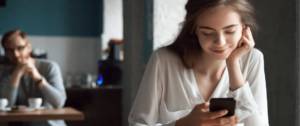 Une adolescente qui regarde son téléphone en souriant