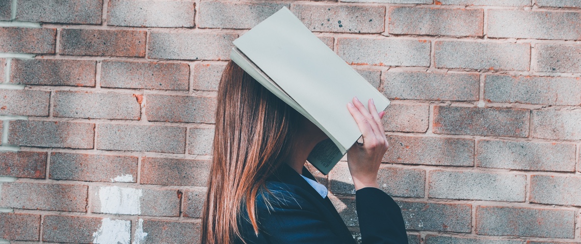La reconnaissance faciale au lycée, ni légale ni nécessaire selon la Cnil jeune femme masquant son visage avec un cahier