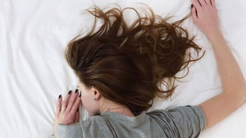 Une femme qui dort sur le ventre