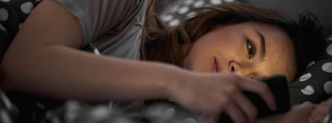 Les vidéos oddly satisfying au secour de notre sommeil une jeune fille allongée dans un lit qui regarde un smartphone